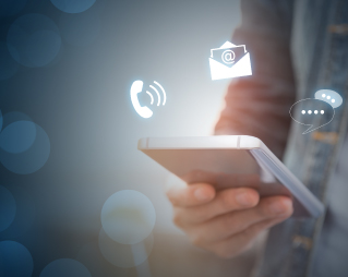 Hand holding a mobile phone.  Background fades from dark blue in the outer edges to hazy lighter shades in the middle.  Icons of a ringing phone, email, and conversations surround the phone.
