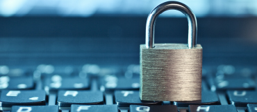 Image of a silver padlock sitting on a keyboard.